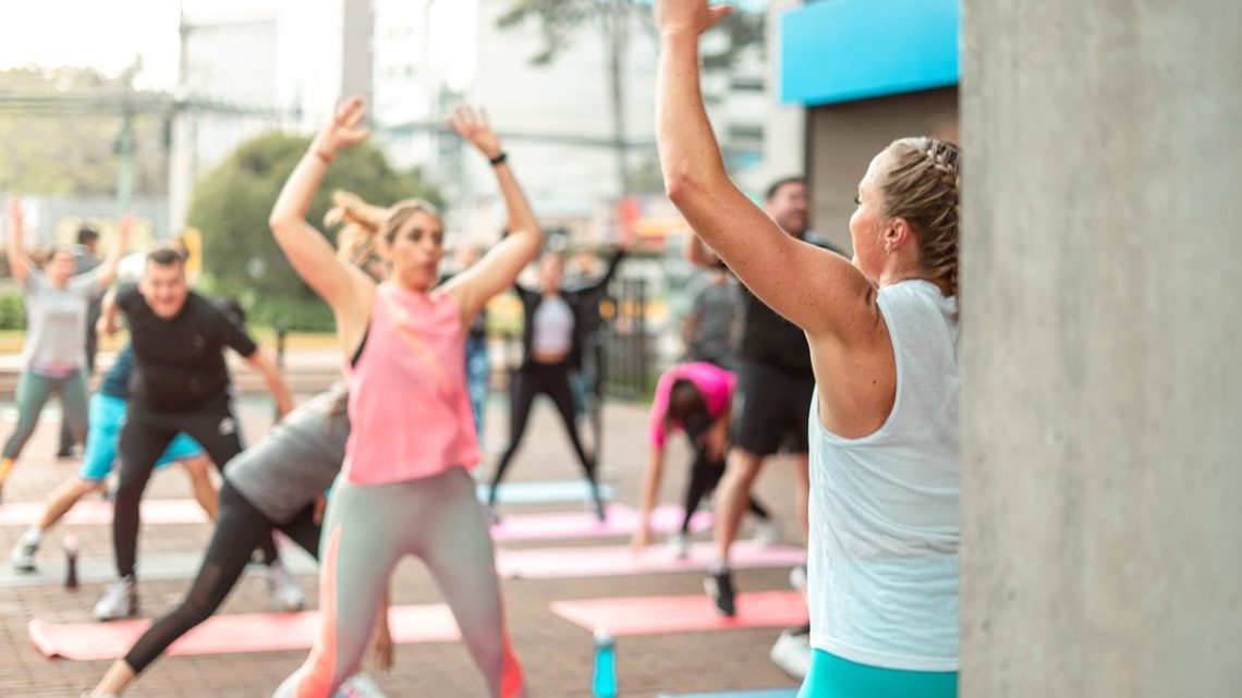 a group of people doing yoga outside on a sunny day