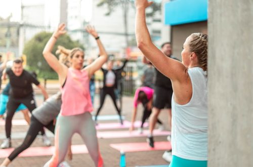 a group of people doing yoga outside on a sunny day