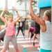 a group of people doing yoga outside on a sunny day